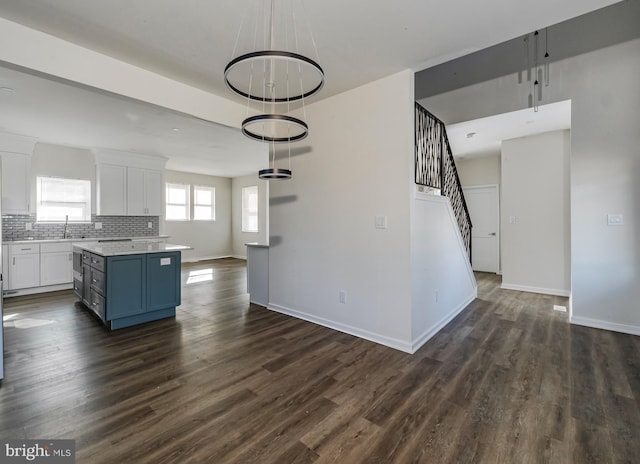 kitchen with blue cabinets, a kitchen island, dark hardwood / wood-style floors, white cabinetry, and hanging light fixtures