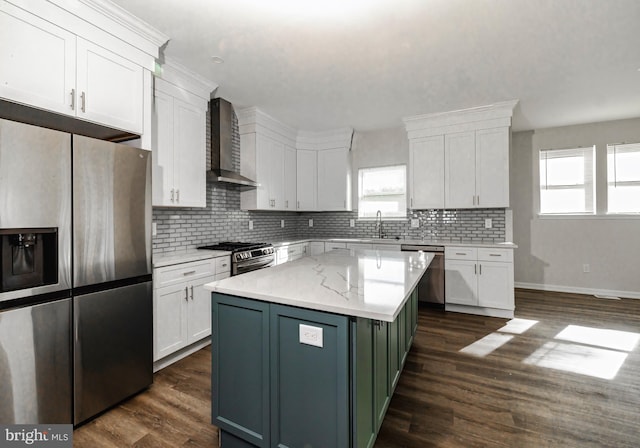 kitchen featuring white cabinetry, wall chimney exhaust hood, dark hardwood / wood-style flooring, a kitchen island, and appliances with stainless steel finishes