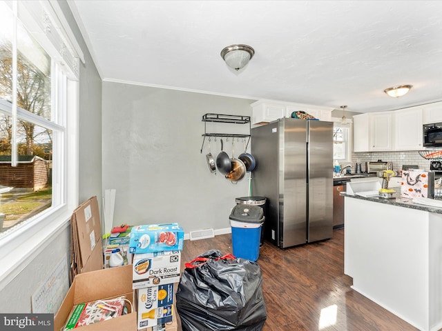 kitchen featuring decorative backsplash, dark hardwood / wood-style flooring, white cabinetry, and stainless steel appliances