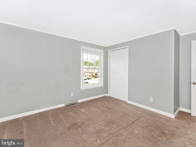 empty room with carpet floors and crown molding