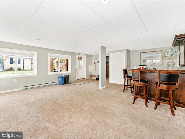 bar featuring a drop ceiling, light colored carpet, and a baseboard radiator