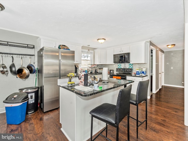 kitchen with a center island, dark wood-type flooring, white cabinets, decorative backsplash, and stainless steel appliances