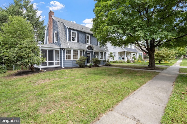 view of front of home featuring a front lawn and a sunroom