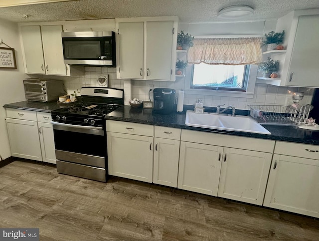 kitchen with white cabinets, stainless steel appliances, tasteful backsplash, and sink