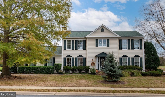 colonial inspired home with a front lawn