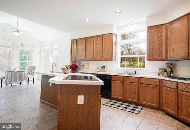 kitchen featuring vaulted ceiling, ceiling fan, a kitchen island with sink, sink, and black appliances