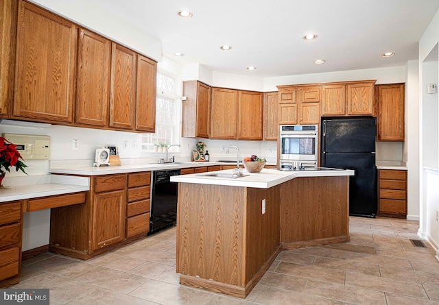 kitchen with a center island with sink, black appliances, and sink