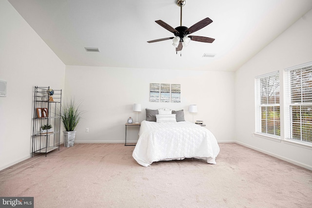 carpeted bedroom with ceiling fan and vaulted ceiling