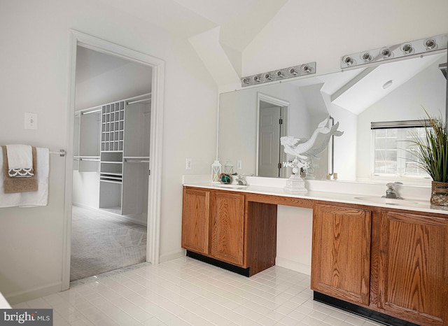 bathroom featuring tile patterned floors, vanity, and vaulted ceiling