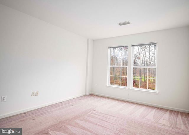 spare room featuring light carpet