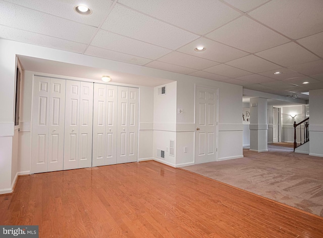 basement featuring hardwood / wood-style flooring and a drop ceiling