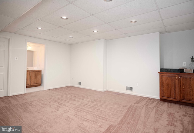 unfurnished room with a paneled ceiling and light colored carpet