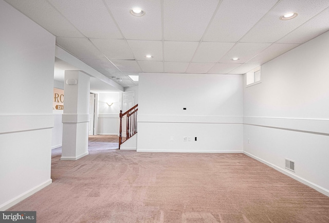 basement featuring light colored carpet and a drop ceiling