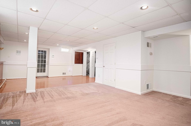 basement with carpet and a paneled ceiling