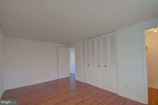 unfurnished bedroom with hardwood / wood-style flooring and a closet