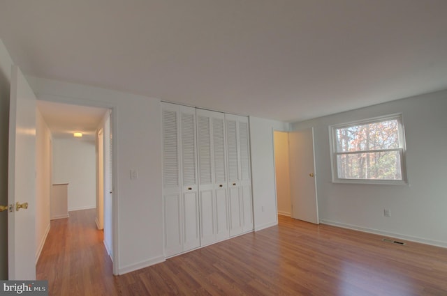 unfurnished bedroom with a closet and light wood-type flooring