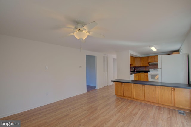 kitchen featuring ceiling fan, light wood-type flooring, white appliances, and kitchen peninsula