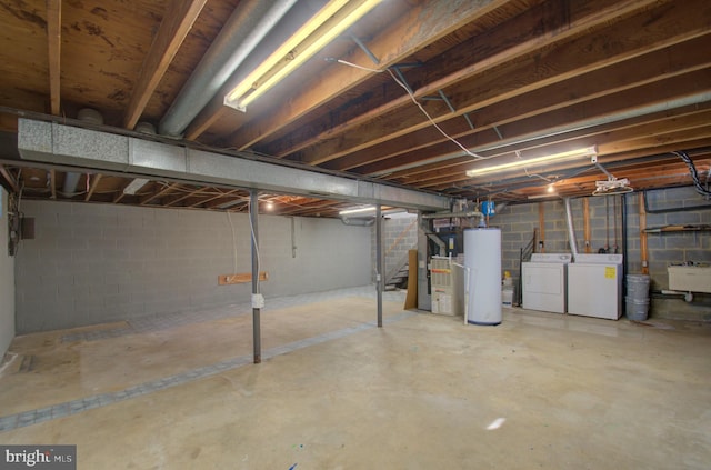 basement featuring heating unit, water heater, washer and clothes dryer, and sink