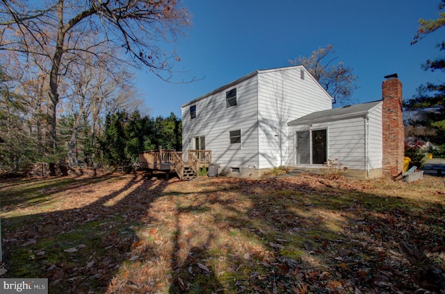 back of house featuring a lawn and a wooden deck