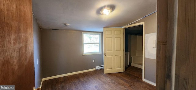 unfurnished bedroom with dark hardwood / wood-style flooring, lofted ceiling, baseboard heating, and a closet