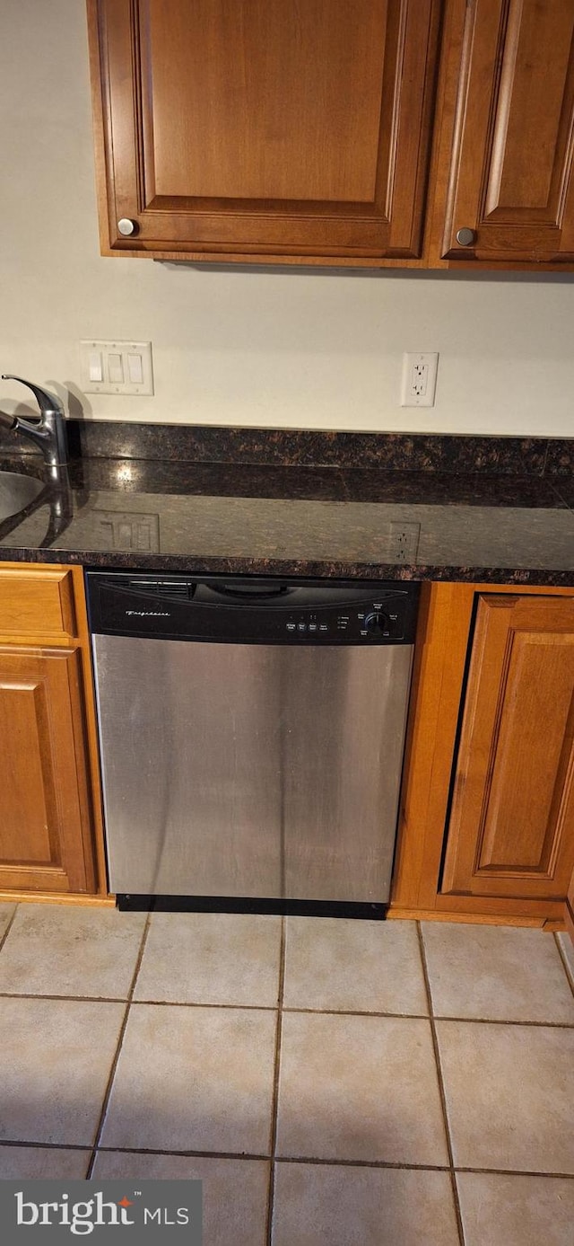 room details with stainless steel dishwasher, dark stone countertops, and sink