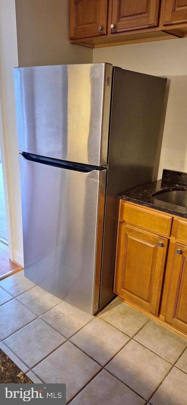 kitchen featuring stainless steel fridge and light tile patterned floors