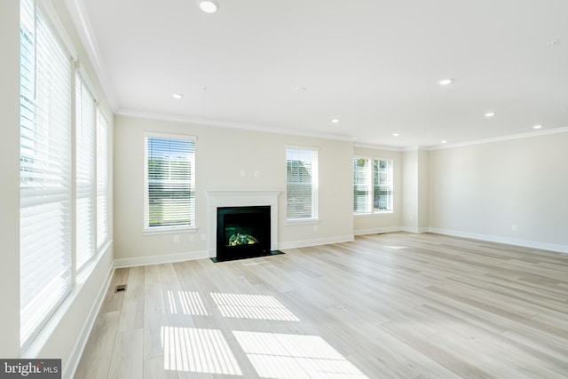 unfurnished living room with ornamental molding and light wood-type flooring