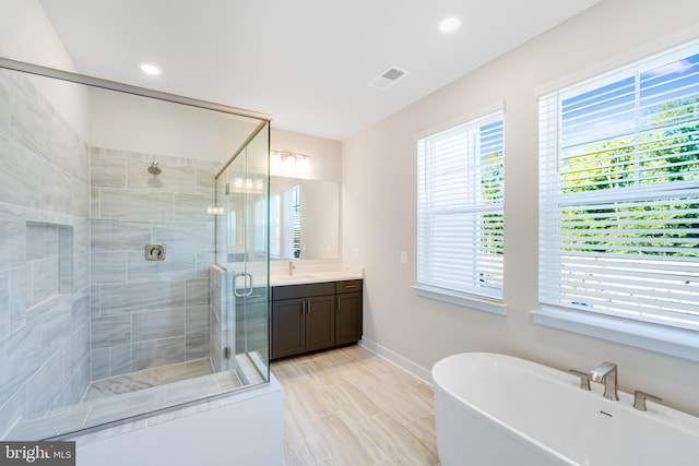 bathroom with vanity and separate shower and tub