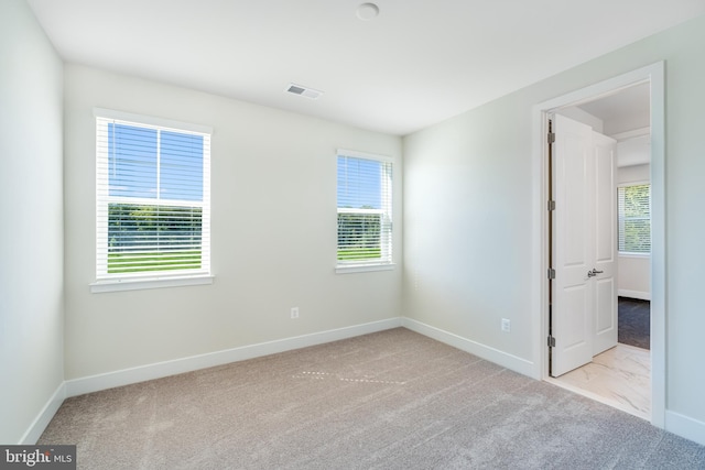 unfurnished room featuring light carpet