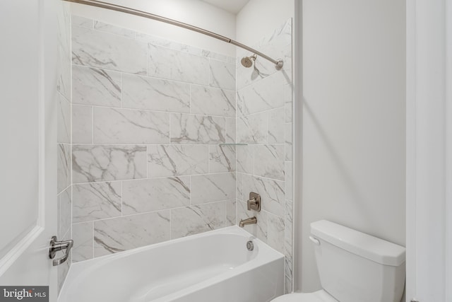 bathroom with toilet and tiled shower / bath