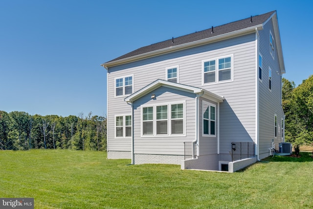 rear view of property featuring a lawn and cooling unit