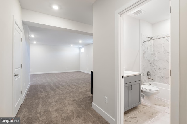 full bathroom featuring vanity, tiled shower / bath combo, and toilet