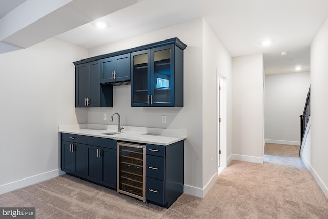 bar with light carpet, sink, beverage cooler, and blue cabinets