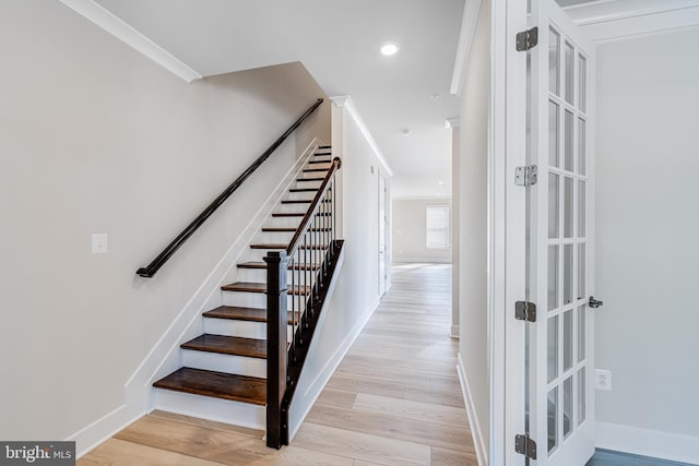 stairs featuring hardwood / wood-style floors and crown molding