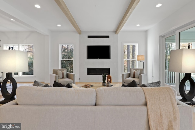 living room featuring a large fireplace and beam ceiling