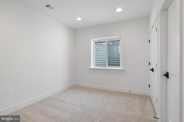 unfurnished room featuring light colored carpet