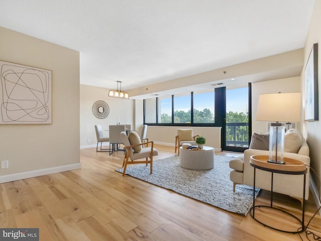 living room with light hardwood / wood-style floors and an inviting chandelier