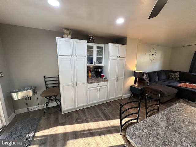 living room with ceiling fan and dark wood-type flooring