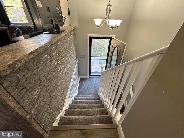 stairs with carpet and a chandelier