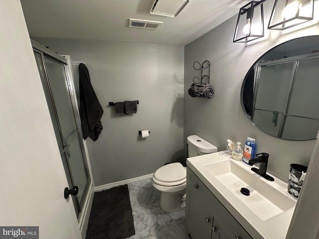 bathroom with vanity, toilet, and a shower with door