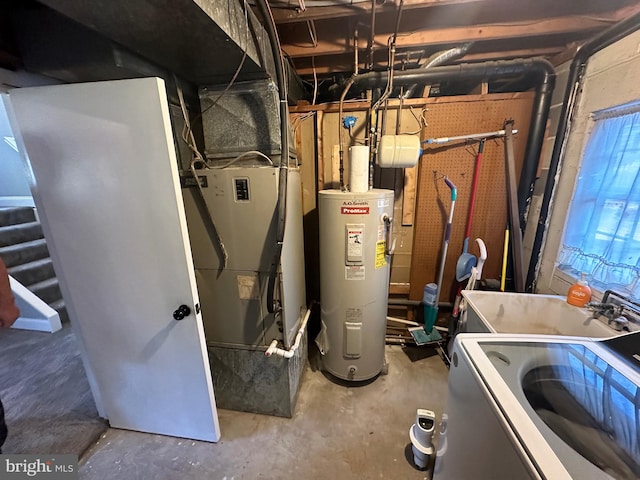 utility room with electric water heater, sink, and washer / dryer