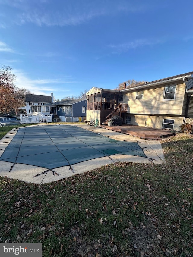 view of swimming pool with a patio area, a sunroom, and a wooden deck