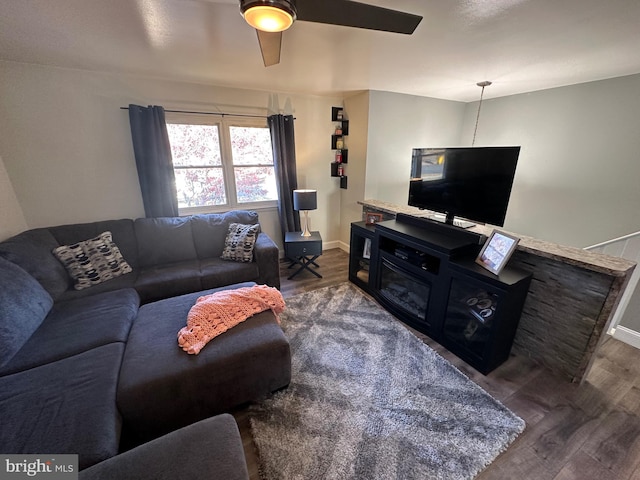 living room featuring ceiling fan and dark hardwood / wood-style flooring