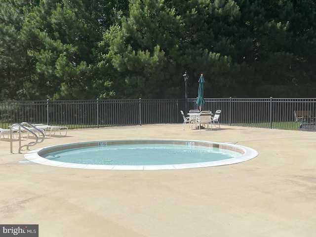 pool with fence and a patio