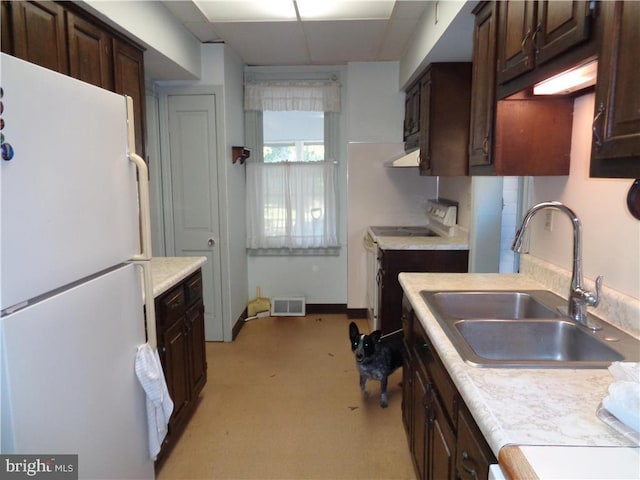 kitchen featuring a drop ceiling, white appliances, sink, dark brown cabinets, and extractor fan