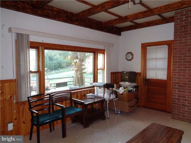 sitting room with wooden walls and beamed ceiling