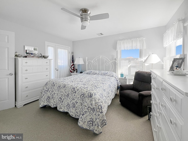 bedroom with ceiling fan, light carpet, and multiple windows