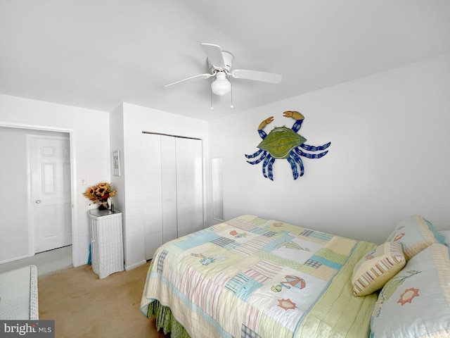 bedroom featuring ceiling fan, light carpet, and a closet