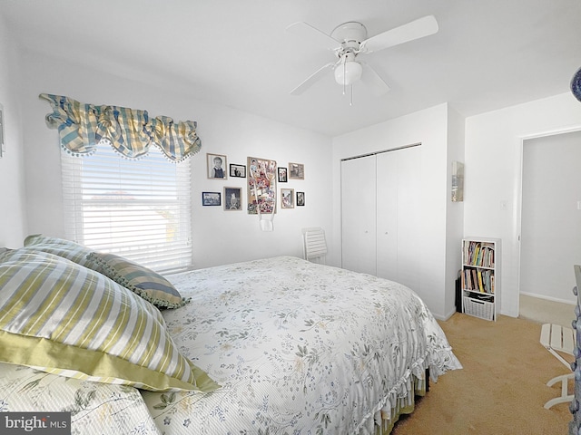 carpeted bedroom featuring ceiling fan and a closet