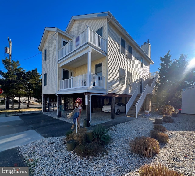 view of front of home with a balcony and a carport